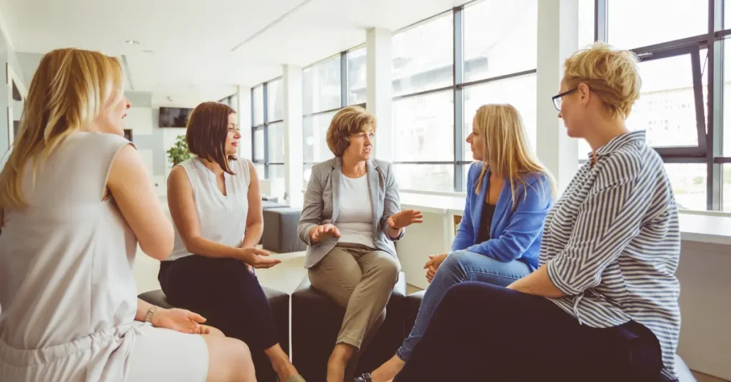 Woman Looking Emotionally Overwhelmed While Family Supports Her